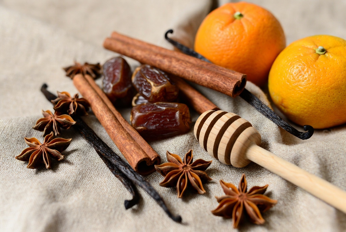 Especias y endulzantes naturales: canela, dátiles, vainilla y miel sobre tela de lino